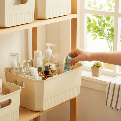 Person organizing beauty products in plastic storage bin with lid on wooden shelf by window
