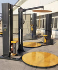 Built Like A Tank Automatic Pallet Wrapper With Plc Touchscreen Panel and Heavy Duty Welded Steel Frame visible in warehouse.