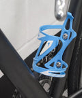 Dope Build Grade Five Titanium Bottle Cage Bolts M5 By 12 Millimeter T25 Torx securing a blue bottle cage on a bike frame.