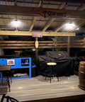 Lit 3000 Lumen Solar Shed Light Hanging Pendant illuminating outdoor gazebo with stools and covered grill at night