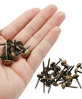Premium Antiqued Brass Upholstery Tacks 24 Piece Set Heavy Duty Furniture Nail Heads grasped in a hand for easy use.
