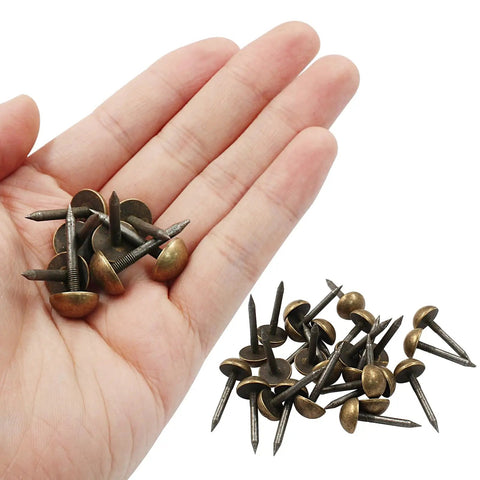 Premium Antiqued Brass Upholstery Tacks 24 Piece Set Heavy Duty Furniture Nail Heads grasped in a hand for easy use.
