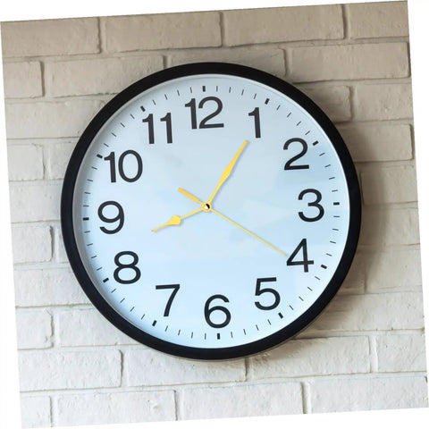Black rim wall clock with yellow hands on brick wall, illustrating Quartz Clock Movement Battery Operated No Tick Silent Wall Clock Mechanism Replacement Kit