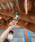 Close-up of a user holding a heavy duty mobile airless paint sprayer cart for butter smooth finishes on home exteriors.