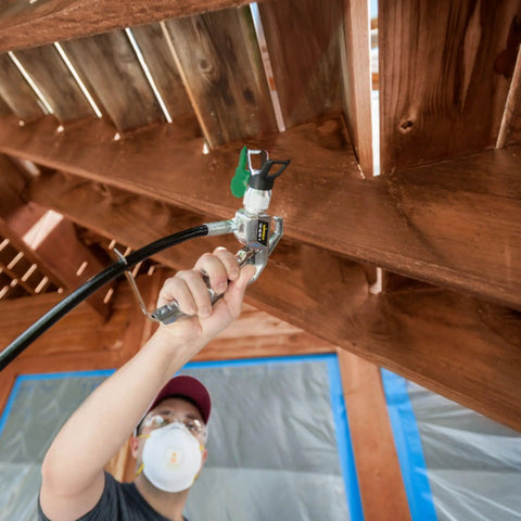 Close-up of a user holding a heavy duty mobile airless paint sprayer cart for butter smooth finishes on home exteriors.
