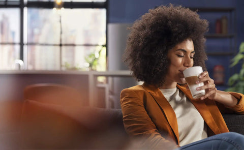 Person enjoying a latte in a glass, with a Ready To Brew Renewed Fully Automatic Espresso Machine With Button Touch Controls.