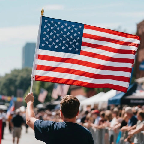 Person holding 3x5 Ft Heavy Duty Outdoor American Flag Deluxe Spun Polyester Waterproof UV Resistant Embroidered Stars in a parade.