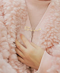 Must Have Set Of Twenty Super Tough Golden Loop Safety Pins To Quick Fix Denim And Anchor Heavy Skirts While Halting Embarrassing Wardrobe Malfunctions Daily, stylishly securing a cozy pink knit cardigan.