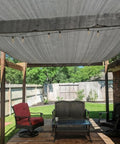 Outdoor patio with 90 Percent UV Blocking Sun Shade Cloth 10x15 Feet With D Rings For Pergola, providing shade over furniture.