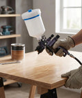 Shop Grade HVLP Paint Sprayer Gun With 600Ml Reusable Gravity Cup And Quick Swap Adapter for wood finishing on a workbench.