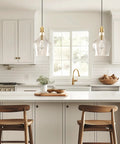 Hand Blown Glass Bell Pendant Light in Gold and Clear, Industrial Farmhouse Style, 9 Inch Shade over kitchen island with wooden stools.