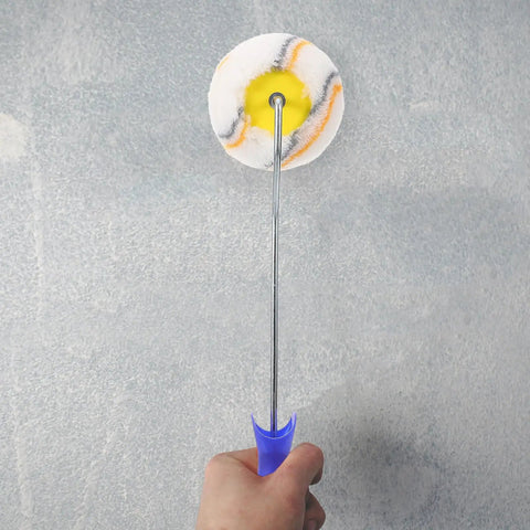 Small Paint Roller With Exact Edge Precision For Tight Spots And House Painting Knockout Tool For Latex Or Oil Based Paints No Sweat Portable Handyman Essential held in hand against a gray wall.