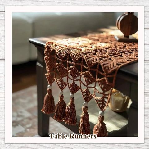 Crochet table runner with tassels on a wooden coffee table.