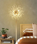 69 Inch Crystal Floor Lamp With K9 Crystals next to a bed, gold finish, modern LED standing lamp in a cozy bedroom setting.