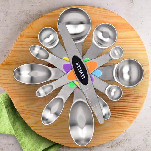 Magnetic Dual Sided Stainless Steel Measuring Spoons Set 7 Piece With Leveler, displayed on a wooden board