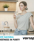 Woman drinking water beside Faucet Water Filter For Sink With Rapid Flow 400 Gallon Faucet Mount Filtration System For Tap Water NSF Certified Cuts Chlorine And No More Funky Taste Includes Four Replacement Filters Easy Install Durable Build For Everyday Use.