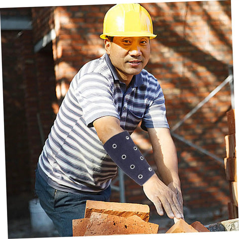 Slip On These Hella Tough Cut Resistant Arm Sleeves For Reliable Lightweight Wrist Guard Protection Built For Mechanic Jobs Welding And Outdoor Projects worn by a man building with bricks outdoors.