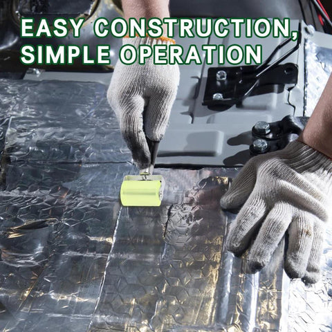 Close-up of automotive seam roller tool with lime-yellow handle applying sound-deadening mat to silver foil insulation.