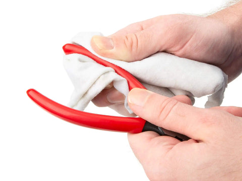 6 Inch 70 Degree Long Nose Pliers With Slim Bent Nose For Tight Obstructions, being wiped clean with a cloth in hand