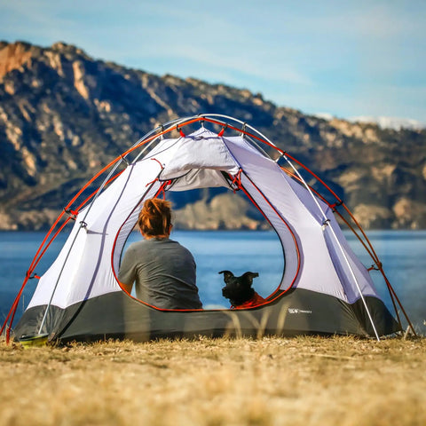 Person and dog in dome tent by lake, showing Heavy Duty Aluminum Tent Poles Replacement Set For Go To Camping Quick Repair.
