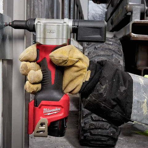Worker using M12 Cordless Rivet Tool Kit for No Fuss Riveting on Aluminum, Steel And Stainless Rivets in outdoor setting