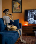 Life Size Skeleton Five Point Four Foot Poseable Full Body Halloween Prop With Movable Joints on couch watching TV indoors