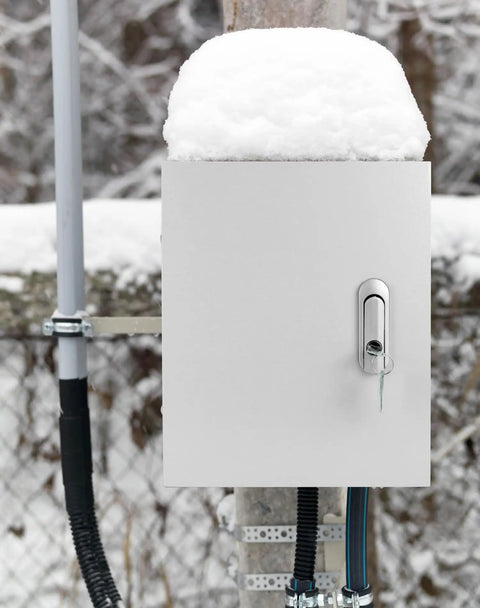 Beefy Heavy Duty Outdoor Electrical Box With Lock And Keys Rugged Fiberglass Reinforced Polyester And Steel Construction 12x10x6 Inch Weatherproof Junction Box For Industrial Mall And Residential Use installed outdoors with snow.