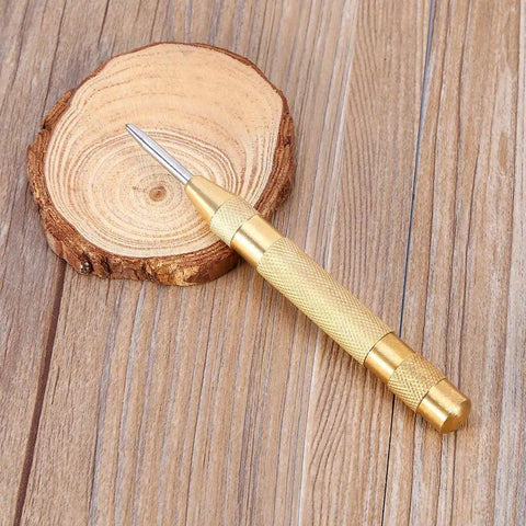 No Sweat Automatic Center Punch Four Piece Kit With Adjustable Spring Impact and High Speed Steel Nose on wood slice.