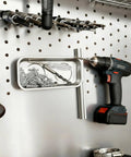 10 Piece Magnetic Tray Set For Tools And Tiny Parts holding screws on a pegboard with drill