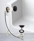 Cable-Driven Bath Drain Trim Kit With Rotary Overflow Cover Knob Pop-Up Stopper And Schedule 40 PVC Fittings 45-Inch Length Oil Rubbed Bronze Finish DIY Friendly Install shown installed in bath.