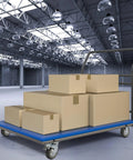 Industrial cart dolly with blue platform and four swivel caster wheels, carrying several cardboard boxes in a warehouse