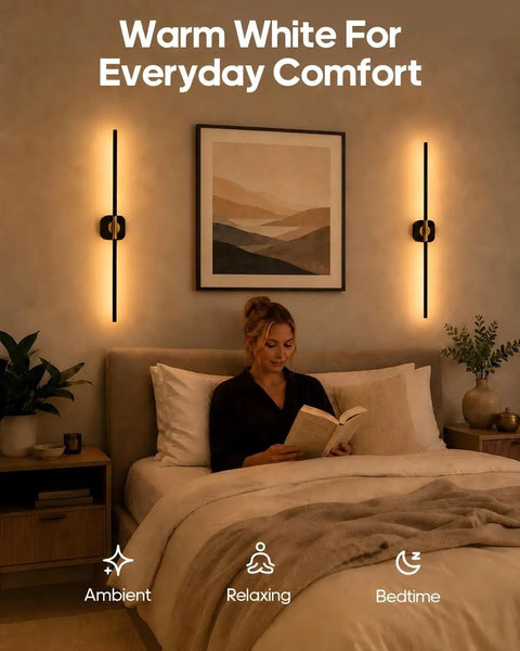 A woman reading in bed by a GOODEA Rechargeable RGB Wall Sconce with 2 Replaceable Batteries providing warm white light.