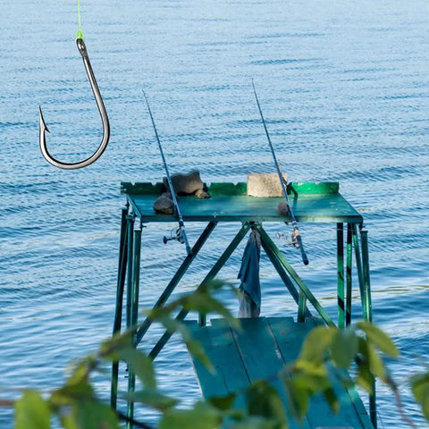 Fishing setup at a dock with a close-up of a hook from the 300Pcs High Carbon Steel Barbed Fishing Hooks With Holes, 10 Sizes set.