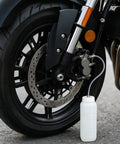 Motorbike front wheel with Brake Bleeder Kit For Cars And Motorbikes With 1L Bleeder Bottle attached for fluid bleeding