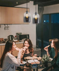 Dope Black Glass Pendant Lights 3 Pack Farmhouse Modern Hanging Island Light With Adjustable Cord illuminating a gathering in kitchen