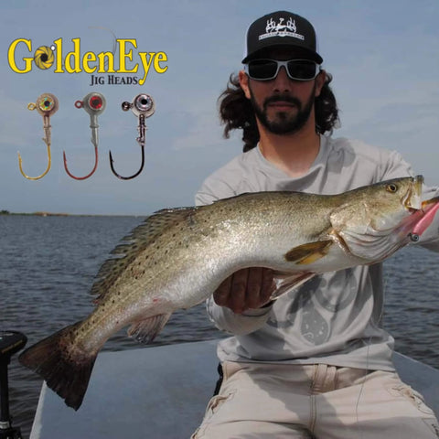 Inshore Jig Head For Soft Plastics With Red Eye And Red Hook 1/4 Ounce 5 Count Pack Perfect For Redfish Speckled Trout Snook Bass Flounder Crappie And More Catches Keepers In 1-6 Feet Of Water shown with angler holding a large fish