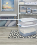 No Hassle Clutter Crusher, Slick Locking Lids, Heavy Duty Stackable Containers For Closet And Home Organization, Roomy 56 Quart Capacity, Clear With White Tops, 12 Pack Deal with folded blankets and pillows.