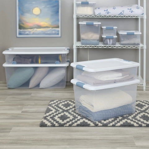 No Hassle Clutter Crusher, Slick Locking Lids, Heavy Duty Stackable Containers For Closet And Home Organization, Roomy 56 Quart Capacity, Clear With White Tops, 12 Pack Deal with folded blankets and pillows.