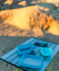 Grab And Go Self Contained Mess Kit With BPA Free Construction And All In One Eating Utensils on outdoor table in camp setting