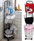 Three-Tier Laundry Cart On Wheels With Heavy-Duty Wire Baskets, filled with clothes and toiletries, in a tiled room corner.