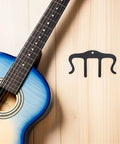 Sturdy Black Metal Sheet Music Clips Set Of 3 For Notebooks And Performances Keeps Pages Open And Stable During Practice Or Gigs A Must Have Piano Sheet Music Holder And Piano Accessories With Wide Compatibility. Black metal clip on wooden surface beside blue guitar