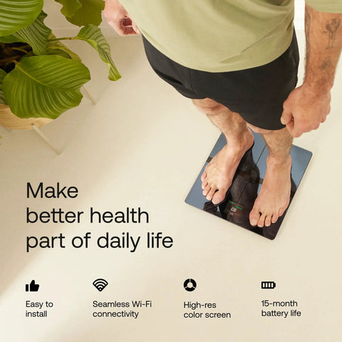 Man standing on smart body scale for precise weight and fat percentage, full body composition readouts, Wi Fi and Bluetooth connectivity.