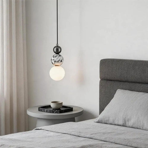 Aolyzmt Natural Alabaster Marble Pendant Light, Modern Cylinder LED Hanging Lamp above a bedside table in a bedroom.