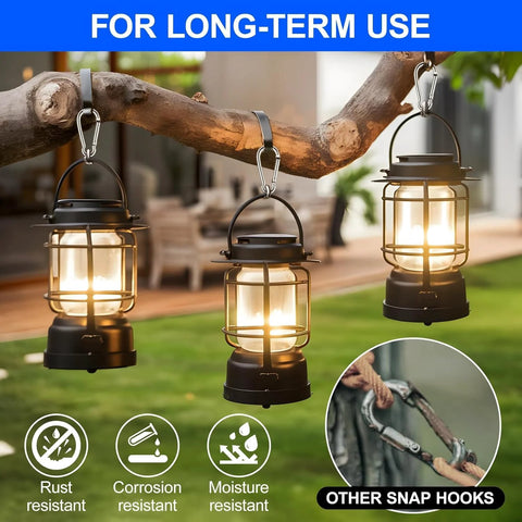 Carabiner clips securing three black lanterns hanging from a branch