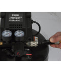 Close-up of Portable 3 Gallon Air Compressor 0.3 HP 110 PSI Max Pressure Oil Free Pump with gauges and hose connection.