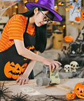 Young woman in witch hat using 8Pcs Halloween Acrylic Router Templates Set for Scary Pumpkin Face Carving on wooden table.