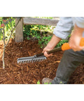 Gardener using 60 Inch Pro Garden Rake With Lightweight Aluminum Handle For Soil A Heavy Duty Gardening Tool For Spreading Mulch Dirt And Gravel Welded Head With Hardened Tines For Maximum Power And Precision In The Yard on mulch