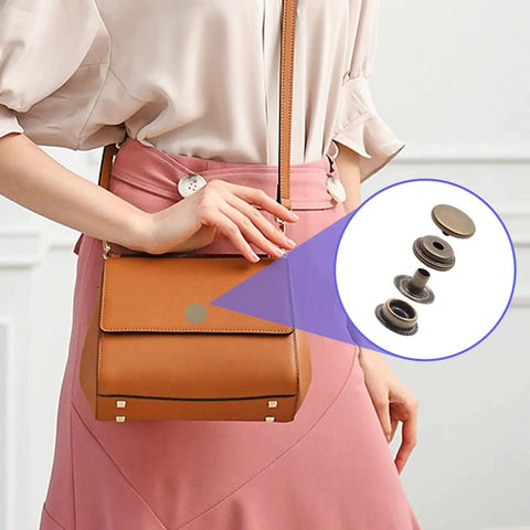 Badass Marine Grade Stainless Steel Snap Fasteners 120 Piece Heavy Duty Press Stud Kit For Boat Canvas Denim Jackets And Diy Craft Tailoring With Rust Proof Antiqued Brass displayed next to a brown handbag.