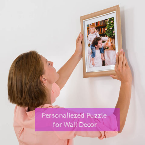 Woman hanging a frame with family photo puzzle on wall, labeled 'Personalized Puzzle for Wall Decor'