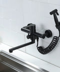 Wall Mount Kitchen Faucet In Matte Black With Side Sprayer, Heavy Duty Stainless Steel Commercial Mixer Tap, installed on wall.
